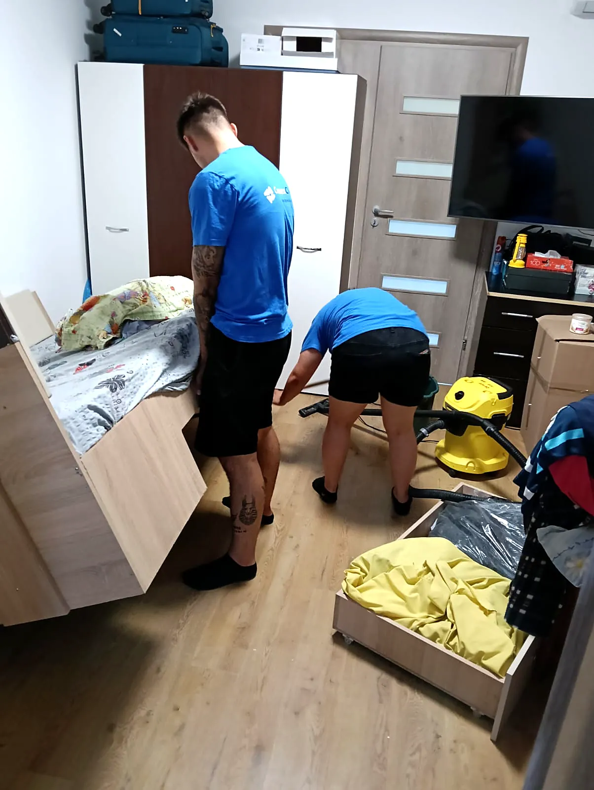 Doi colegi Conex Clean făcând curățenie generală într-un dormitor