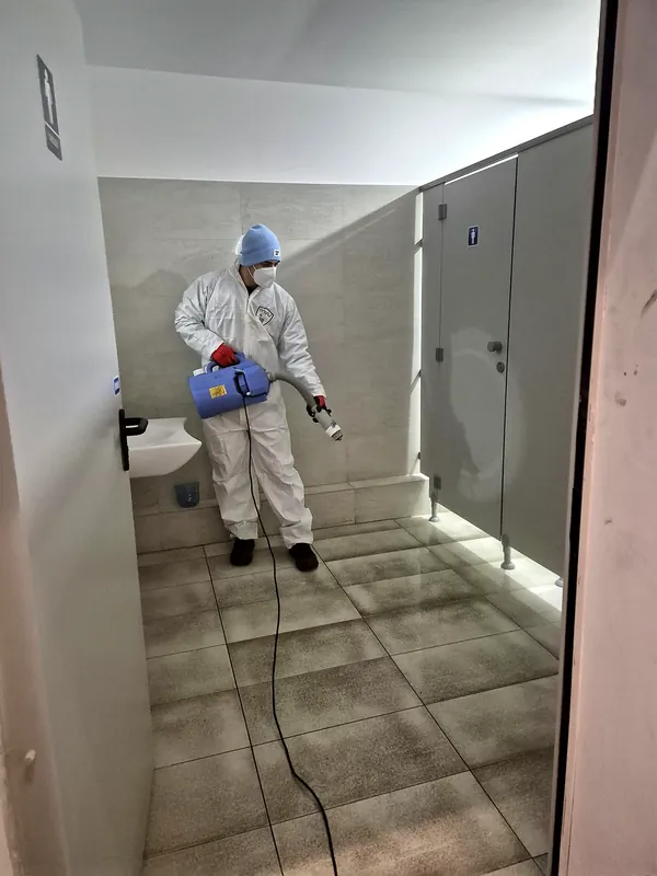 Operator DDD dezinfectând grupurile sanitare ale unei firme